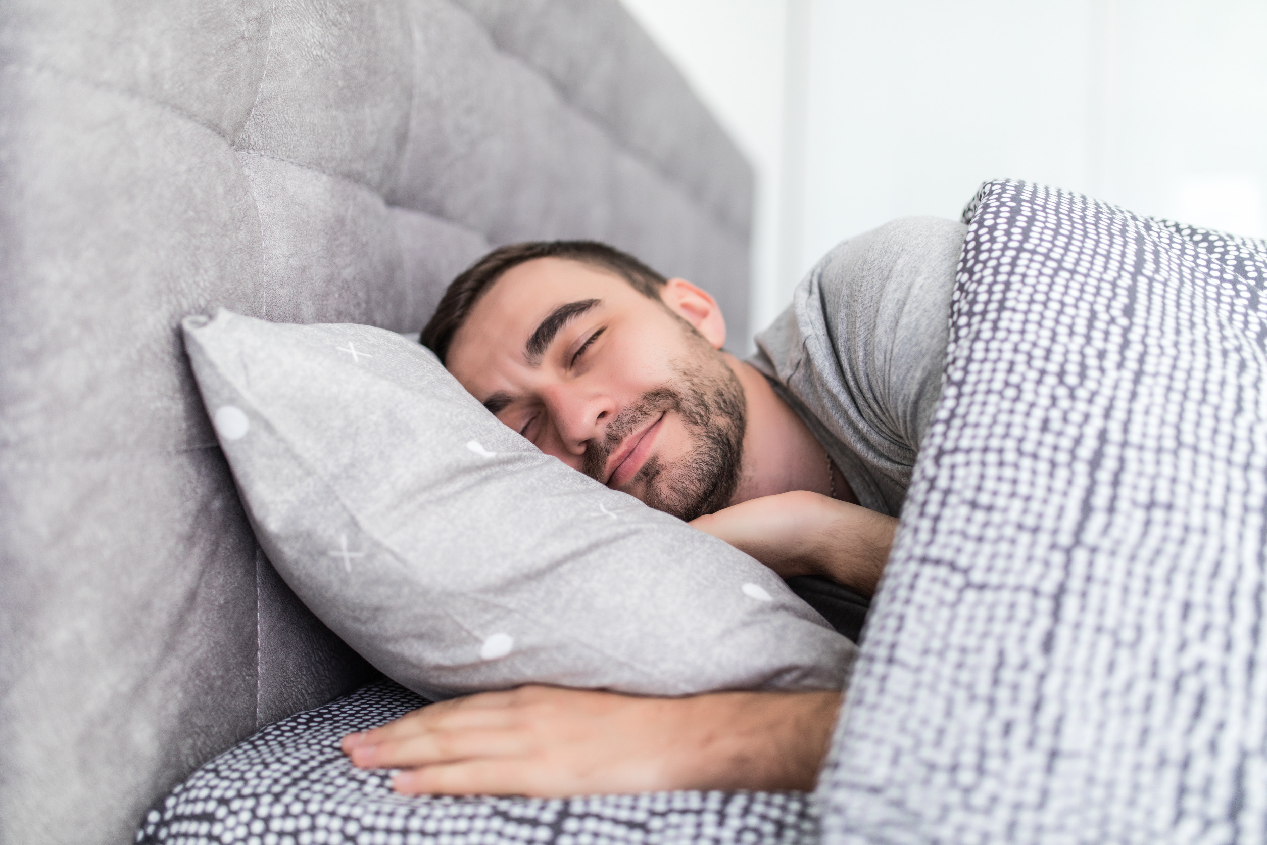 A man sleeping in his bed comfortably