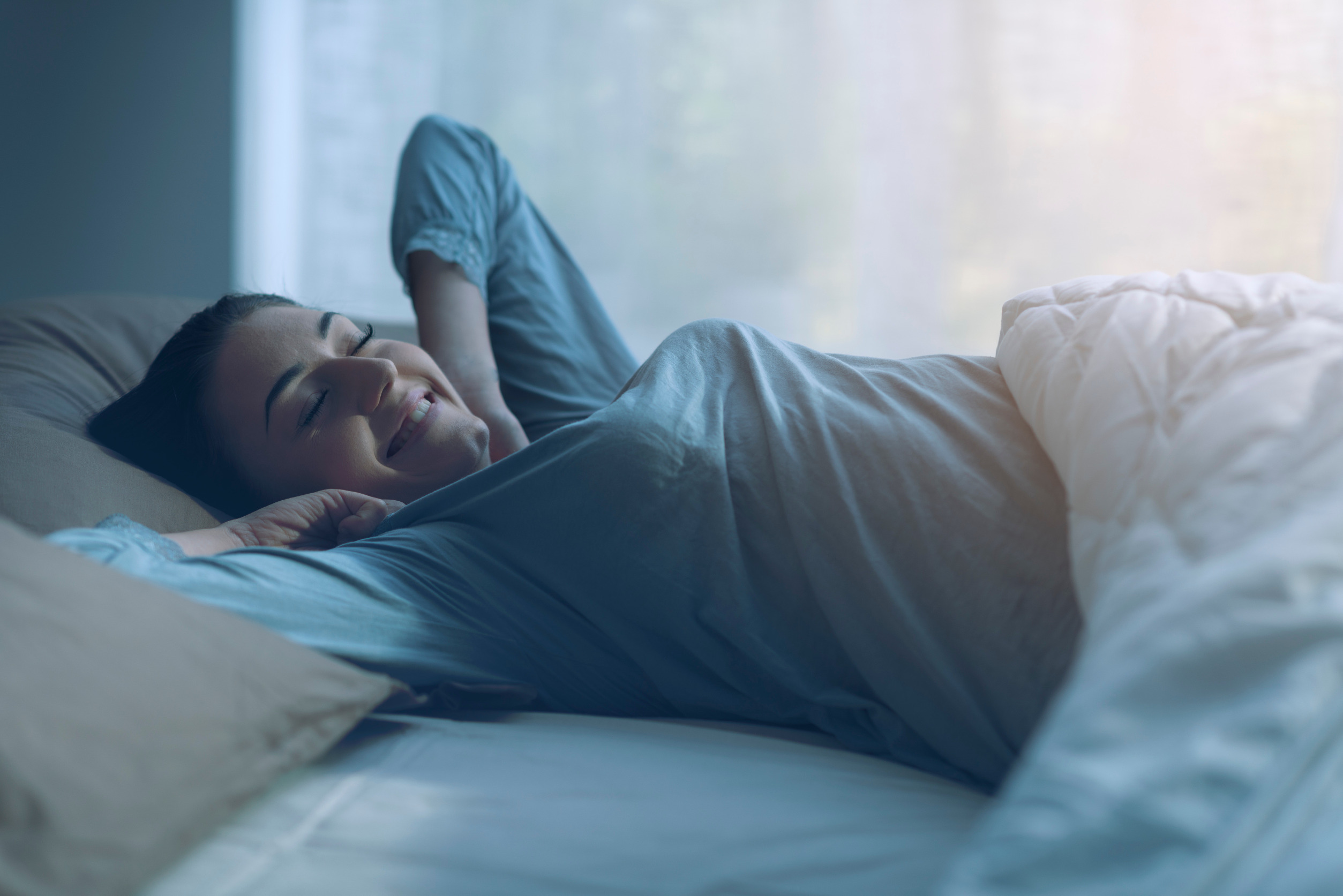 A women waking up stretching with a smile on her face