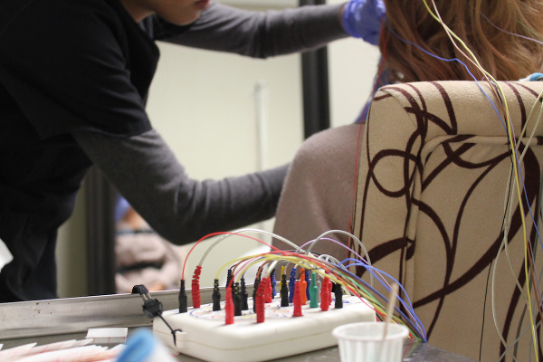 A woman lying in a bet with sleep diagnostic electrodes connected to her